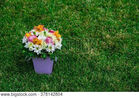 A Bouquet Of Colorful Flowers In A Hatbox On A Green Lawn. Top View. Place For Text.