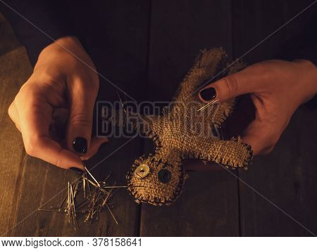 Voodoo Doll In Womens Hand Pierced With Many Needles, As A Symbol Of Revenge And Causing Harm To Peo