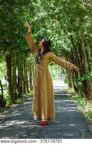 Armenian Young Woman In Traditional Clothes Dancing In The Forest