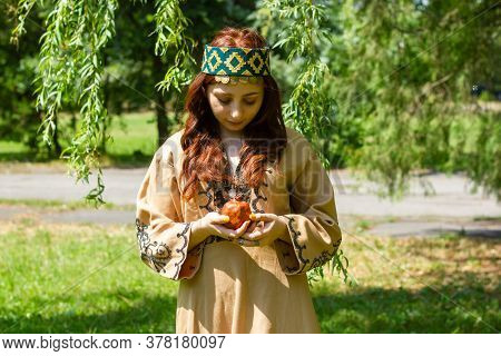 Armenian Young Woman In Traditional Clothes In The Forest With Pomegranate