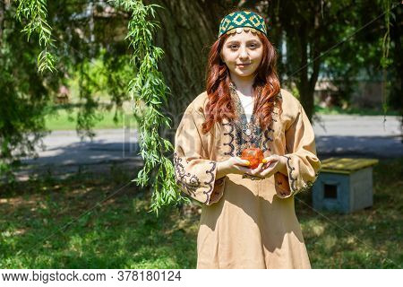 Armenian Young Woman In Traditional Clothes In The Forest With Pomegranate