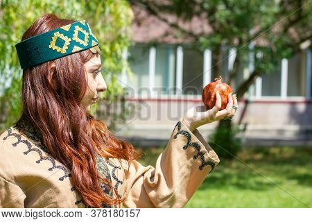 Armenian Young Woman In Traditional Clothes In The Forest With Pomegranate