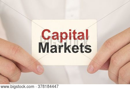 Businessman Holding A Card With Text Capital Markets