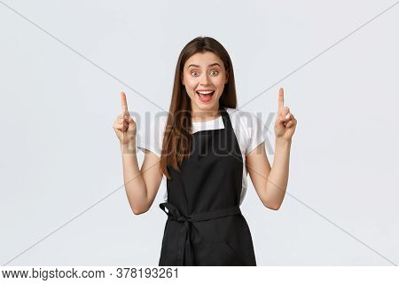 Small Business, Employees And Coffee Shop Concept. Confient Pretty Barista In Black Apron Pointing F