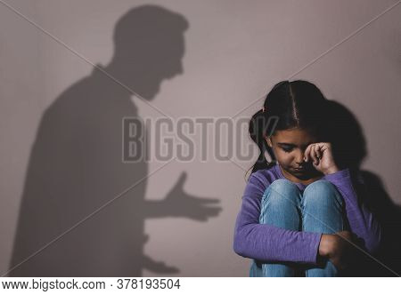 Child Abuse. Father Yelling At His Daughter. Shadow Of Man On Wall