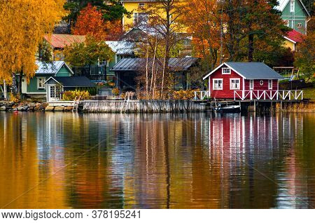 Colorful Houses And Trees Reflecting In The Water Surface. Autumn In Rauma, Finland.