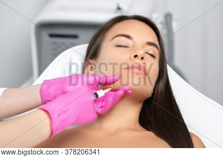 Cosmetologist Makes Lipolytic Injections To Burn Fat On The Chin, Cheeks And Neck Of A Woman Against