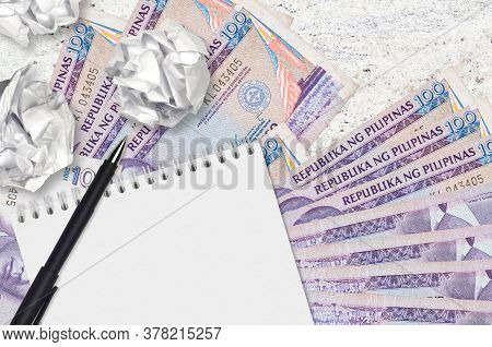 100 Philippine Piso Bills And Balls Of Crumpled Paper With Blank Notepad. Bad Ideas Or Less Of Inspi