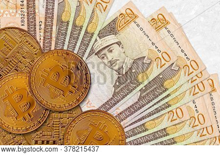 20 Dominican Peso Bills And Golden Bitcoins. Cryptocurrency Investment Concept. Crypto Mining Or Tra
