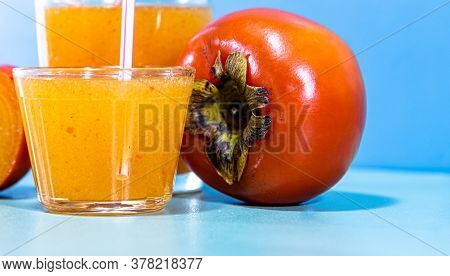 Fresh Fruit Juice And Persimmon (diospyros Kaki L.) On Blue Background