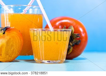 Fresh Fruit Juice And Persimmon (diospyros Kaki L.) On Blue Background