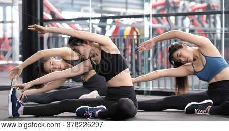 Group Of Sporty Young Asian Women In Sportswear Warming Up With Gymnastics And Stretching Exercises 
