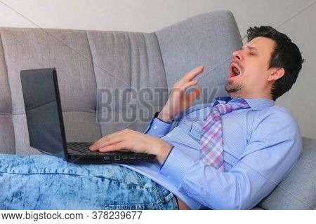 Freelancer Man Working Typing On Laptop At Home Sitting On Couch, Freelance Distant Work On Quaranti