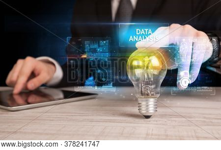 Businessman holding lightbulb with DATA ANALYSIS inscription, online security idea concept