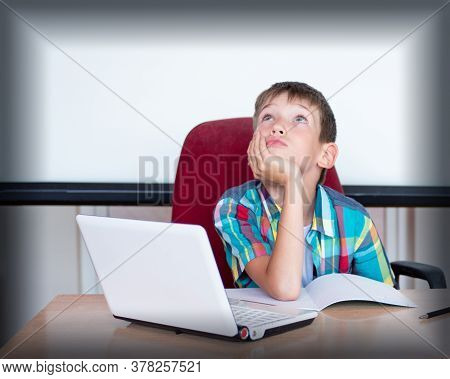 A Cute Boy Sits At The Table, Looks Up, Remembers His Homework. The Boy Didnt Learn His Homework