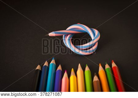 Flexible Pencil And A Set Of Colored Pencils On A Dark Background. Selective Focus