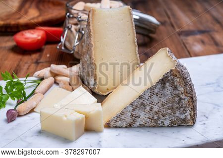 Pieces Of Cheese Tomme De Montagne Or Tomme De Savoie Made From Cow Milk In French Alps.