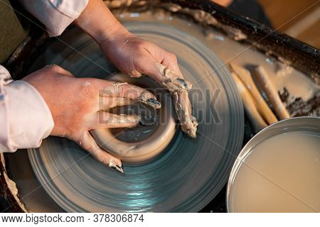 Close Up Of Woman Hands Working On Pottery Wheel With Clay