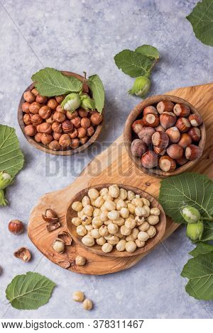 Top View Of Hazelnuts With Peeled Hazelnut And Leaf  In Brown Bowl On Concrete Background. Top View 