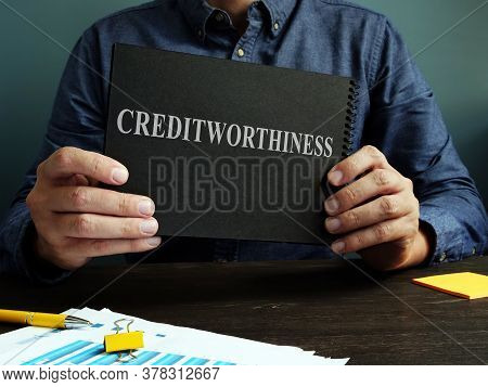 The Man Shows An Sign Creditworthiness On A Black Page.
