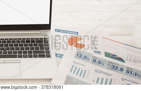 Laptop On Table With Finance Statements, Calculator On White Background