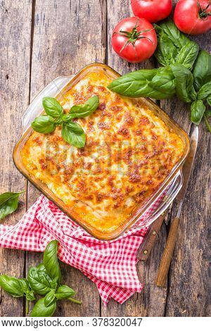 Traditional Italian Lasagna With Vegetables, Basil, Minced Beef Meat, Tomato And Cheese On Wooden  B