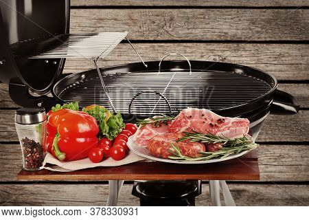 Barbecue Grill With Meat Products And Vegetables On Wooden Background, Closeup