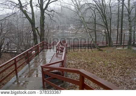 Gloomy Autumn. Puddles On The Wooden Floor Of The Footpath Leading To The Pond. Overcast, Fog, End O
