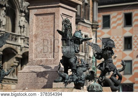 Close-up Ancient Statue Of Putto Killing Devil At The Marian Column\'s Pedestal Marienplatz, Munich,