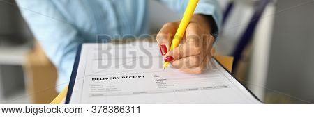 Close-up Of Woman Filling Delivery Receipt Document. Female With Nice Red Manicure Holding Yellow Pe
