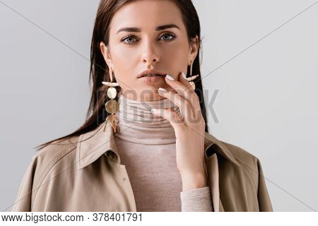 Beautiflul, Stylish Girl Touching Face While Looking At Camera Isolated On Grey