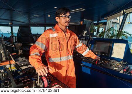 Filipino Deck Officer On Bridge Of Vessel Or Ship. He Is Speaking On Gmdss Vhf Radio