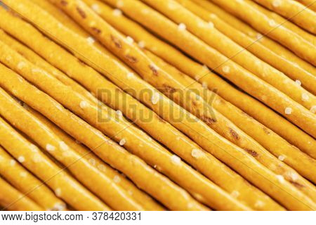 Salty Sticks Line In Row Background. Top View. Snack Texture Background. Salty Bread Sticks For Beer