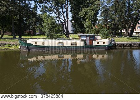 Lokeren, Belgium, Houseboat Moored On The Rippling Water Of The River Durme