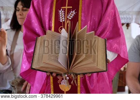 CHUNAKHALI, INDIA - FEBRUARY 26, 2020: The priest holds the missal, Catholic church in Chunakhali, West Bengal, India