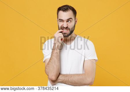 Preoccupied Worried Young Bearded Man Guy In White Casual T-shirt Posing Isolated On Yellow Wall Bac