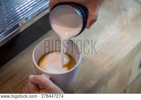 Barista In Cafe Or Coffee Bar Preparing Proper Cappuccino Pouring Milk Froth In A Cup. Waiter Hands 