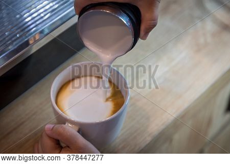 Barista In Cafe Or Coffee Bar Preparing Proper Cappuccino Pouring Milk Froth In A Cup. Waiter Hands 