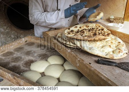 A Male Cook Makes Tortillas. The Preparation Of Bread. The Process Of Baking Bread In A Traditional 