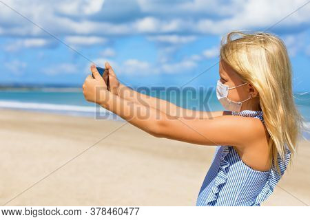 Funny Girl Taking Selfie Photo By Smartphone On Tropical Sea Beach. New Rules To Wear Cloth Face Cov