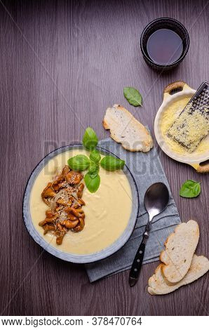 Traditional Polenta With Mushrooms And Cheese In A Dish On A Dark Wooden Background. Selective Focus