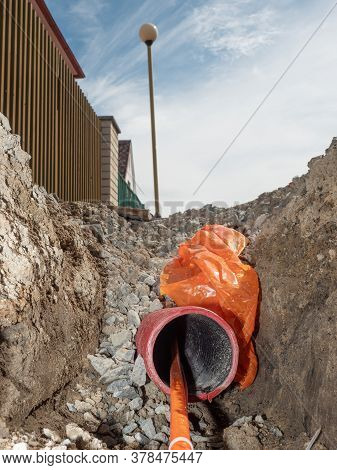 Detail Of Optic Fiber Wire In Ribbed Flexible Red Plastic Tube, Thin Trench At Lamp Post