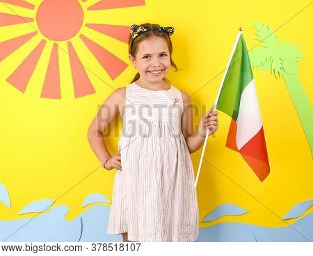 Little Girl On A Bright Background With Italian Flag. The Concept Of Summer, Beach Holidays And Vaca