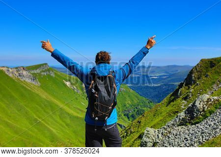 man happy on top of mountain