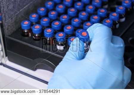Close Up Woman Hand In A Rubber Gloves Put Sample In A Glass Vial With Blue Cap Into The Autosampler