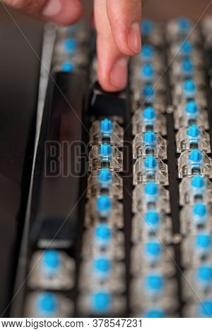 Caucasian technician repairing a mechanical keyboard with blue switches