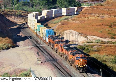 July 27, 2020 In Cajon Pass, Ca:  Freight Train With Four Locomotives Hauling Uphill Rail Cars Uphil