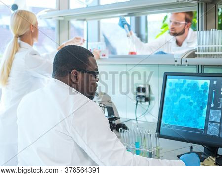 Scientist and students working in lab. Doctor teaching interns to make blood analyzing research. Coronavirus, chemistry, bacteriology, virology and health care