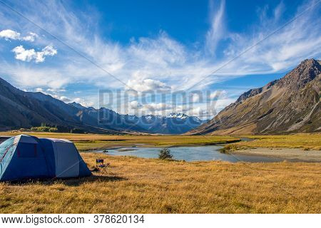 A Tent Pitched Beside The Ahuriri River, Surrounded By Mountains, In Cantebury, South Island, New Ze