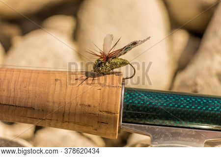 A Macro Shot Of An Artificial Cicada Dry Fly For Fishing For Trout, Positioned On The Cork Handle Of
